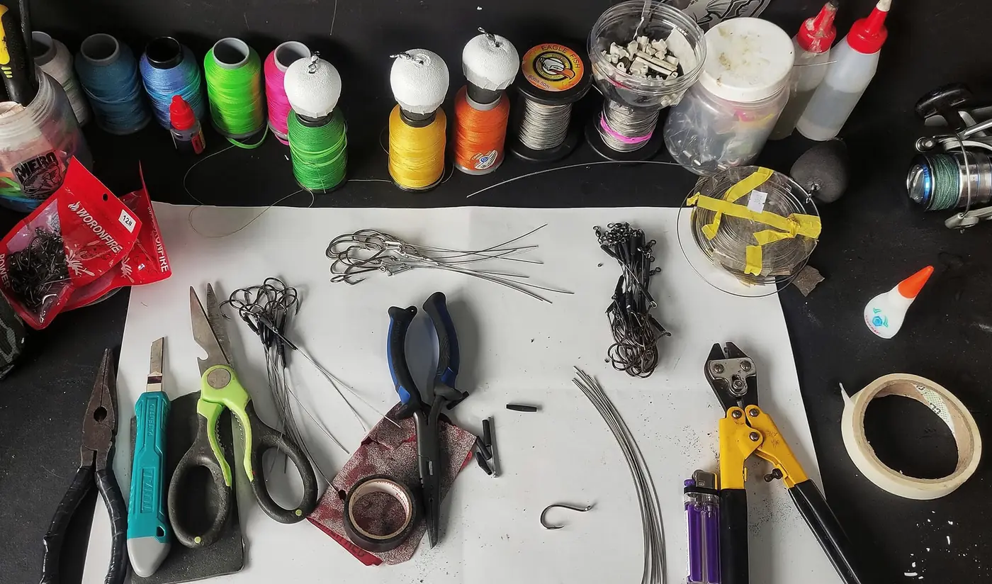 Mesa de trabajo de Mero Fishing con anzuelos, guaya, giratorios y alicates para armar aparejos