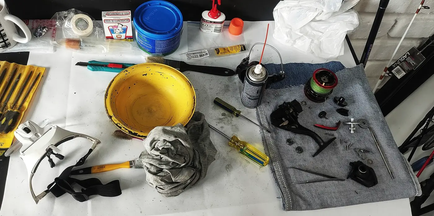Carrete desarmado sobre la mesa del taller para limpieza y mantenimiento